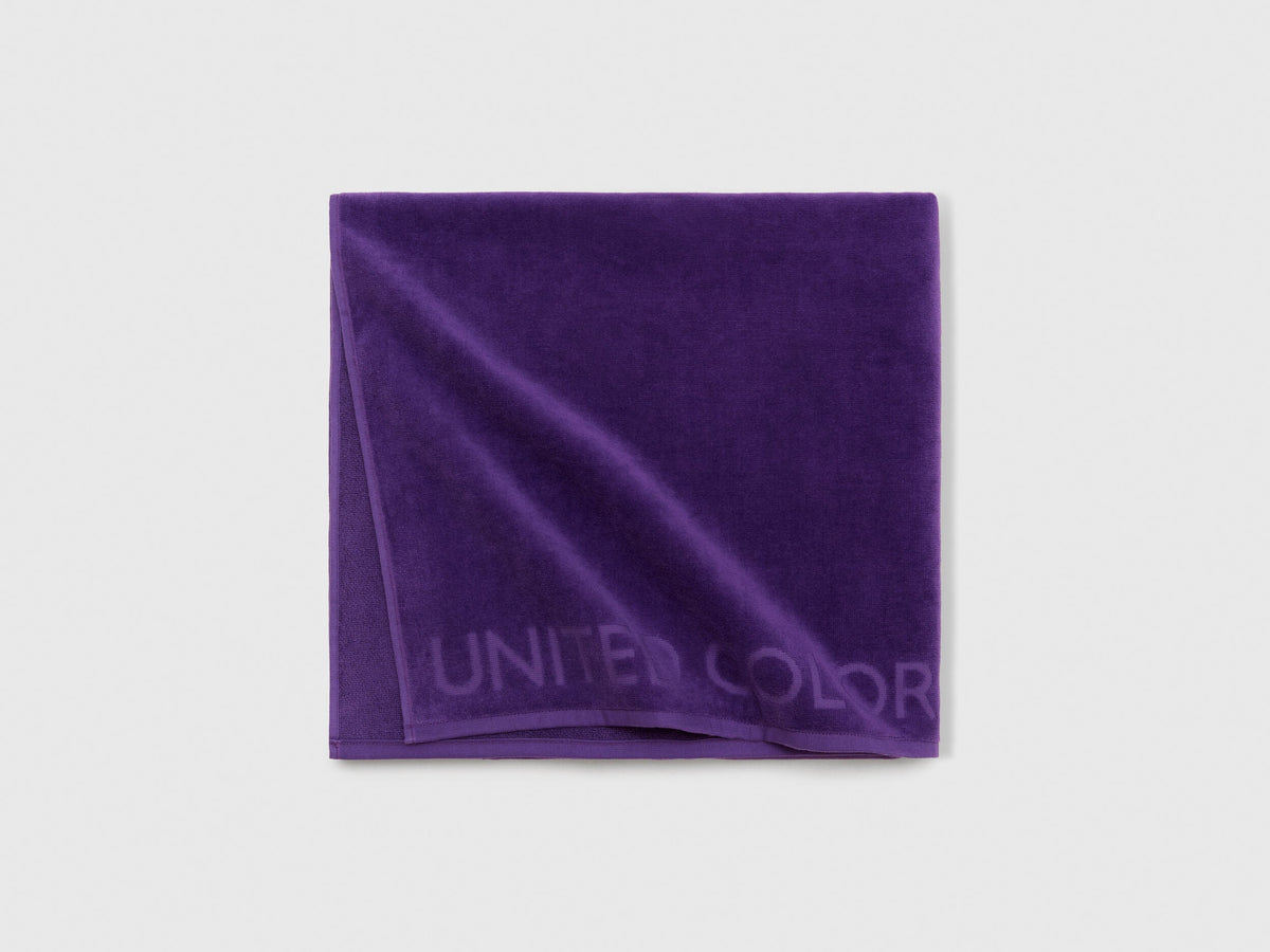 Close-up detail of the soft and absorbent fabric texture of a purple beach towel.
