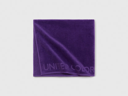 Close-up detail of the soft and absorbent fabric texture of a purple beach towel.