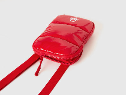 Close-up of a red cell phone case, showing the quilted fabric, zipper, and Benetton logo.