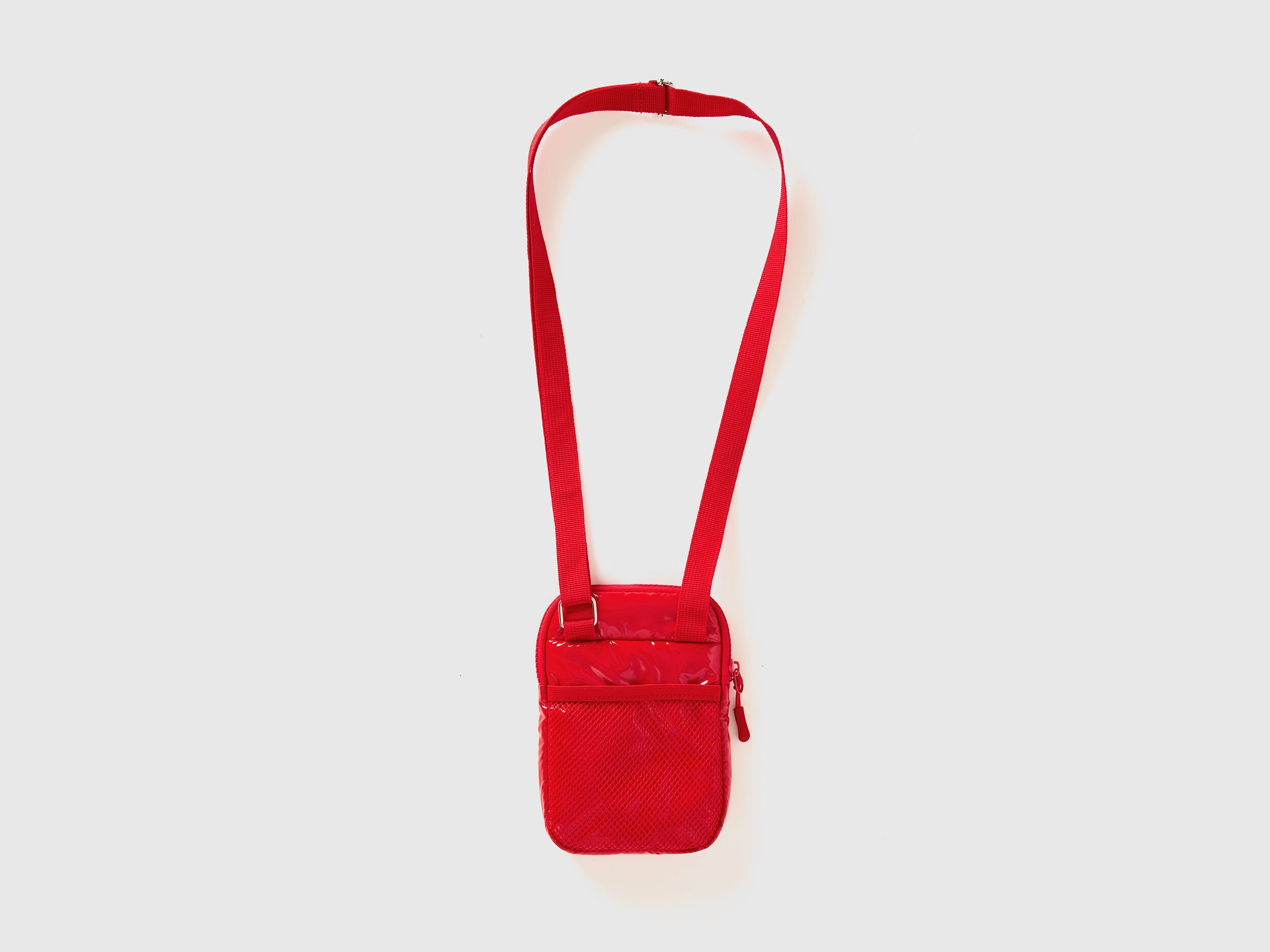 Side view of a red cell phone case with a shoulder strap and quilted texture. Compact.