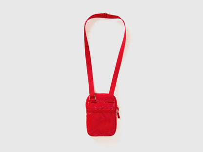 Side view of a red cell phone case with a shoulder strap and quilted texture. Compact.