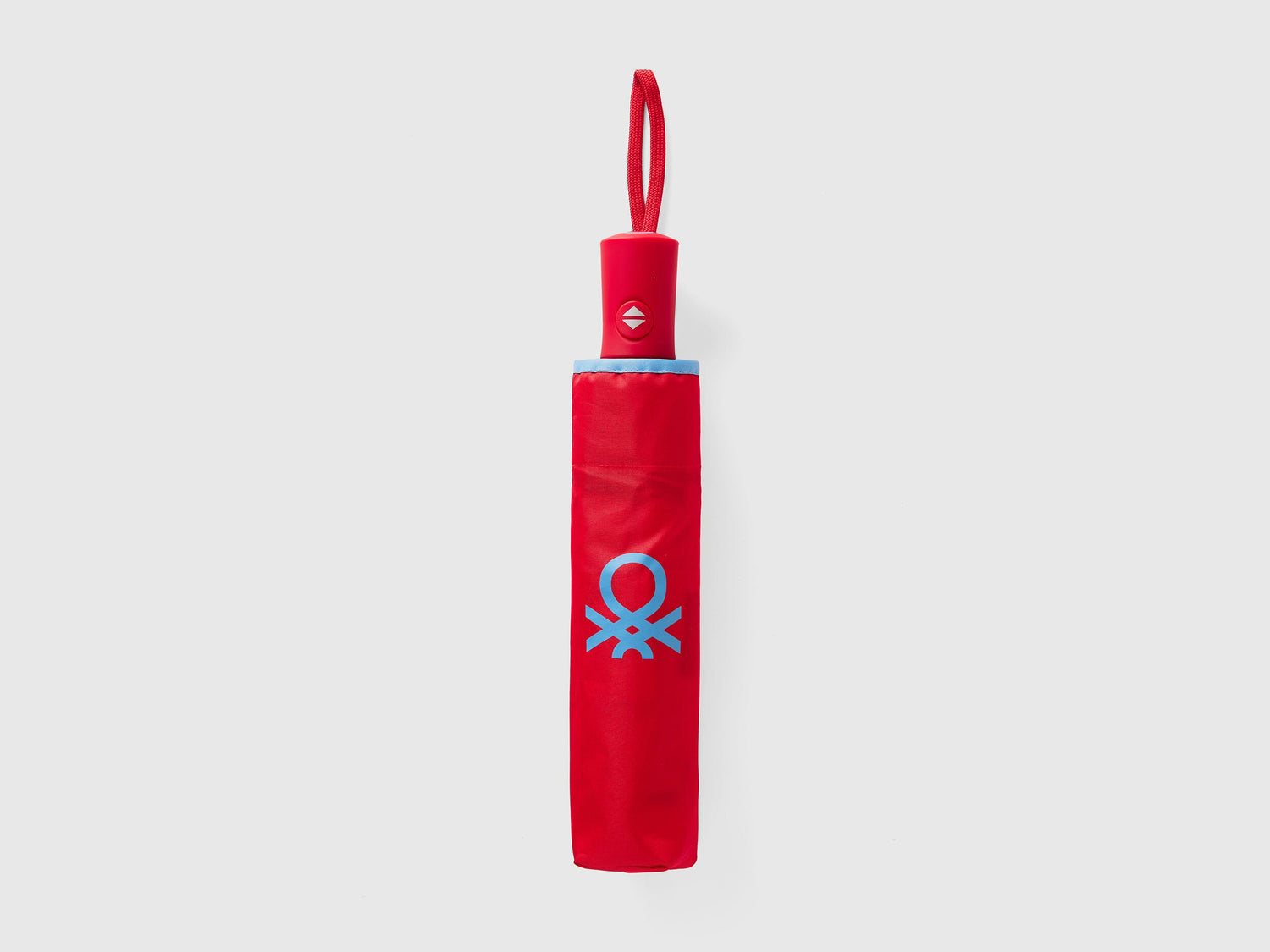 Folded red Benetton umbrella, compact for portability.