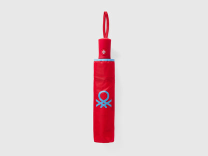 Folded red Benetton umbrella, compact for portability.