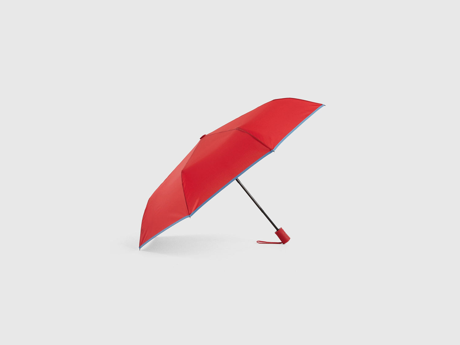 Red Benetton umbrella, partially open, stylish rain gear.