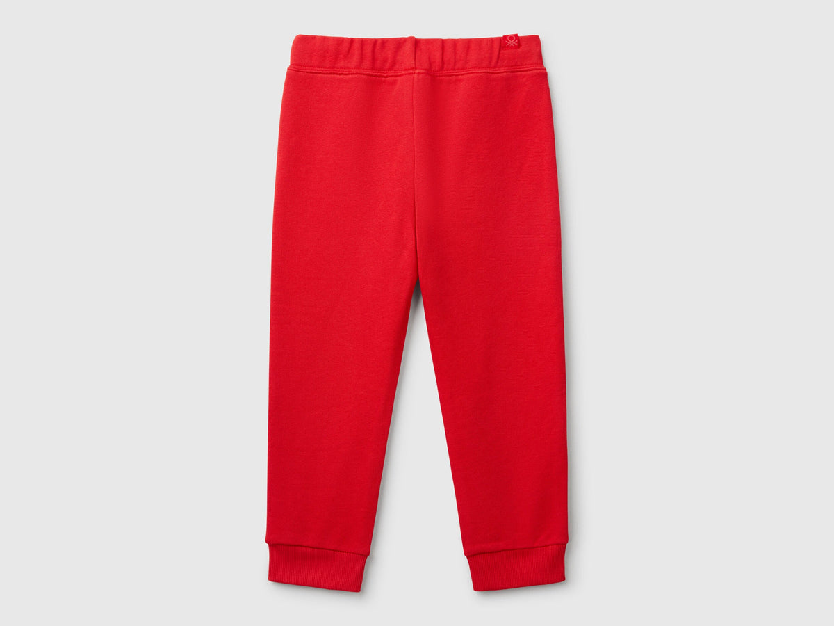 Back view of plain red sweet pants.