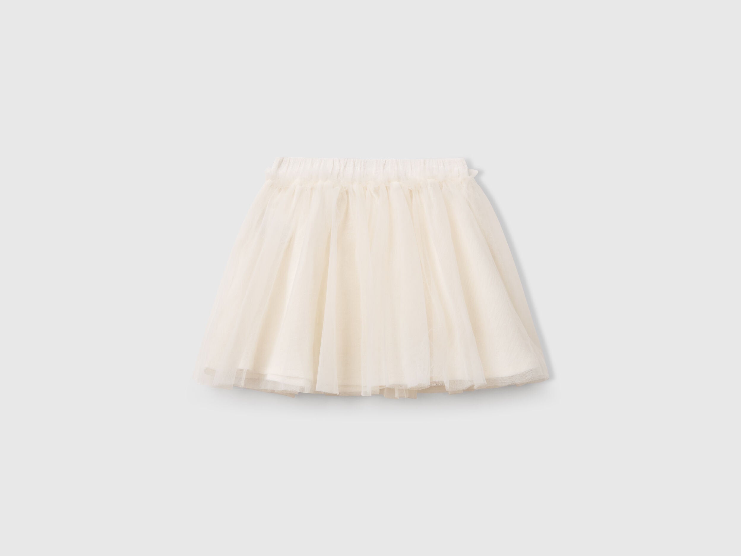 Back view of a white Benetton tulle skirt, showing its flowing layers and elastic waistband.