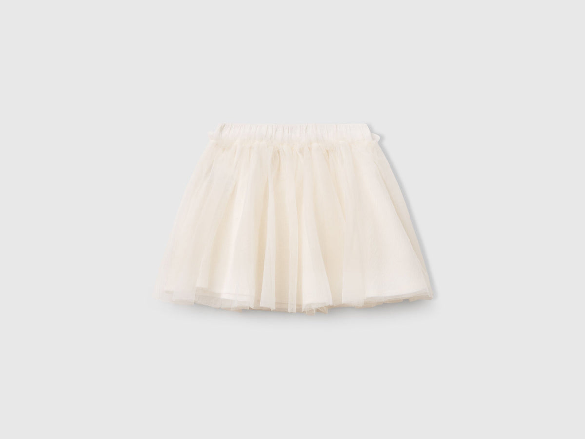 Front view of a white Benetton tulle skirt, featuring a full, ruffled silhouette. Lightweight and airy.