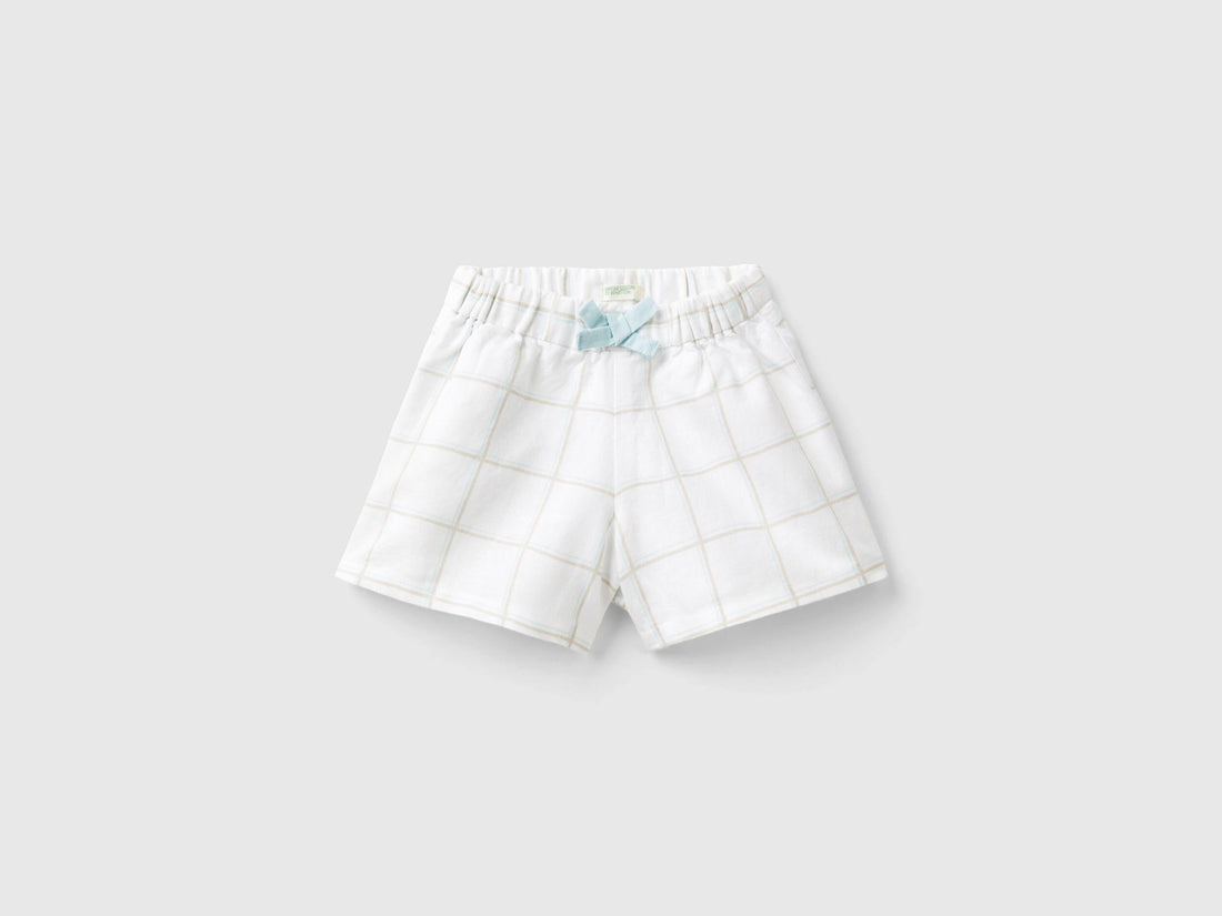 Front view of white and blue checkered culottes for kids, featuring a cute bow detail at the waist.