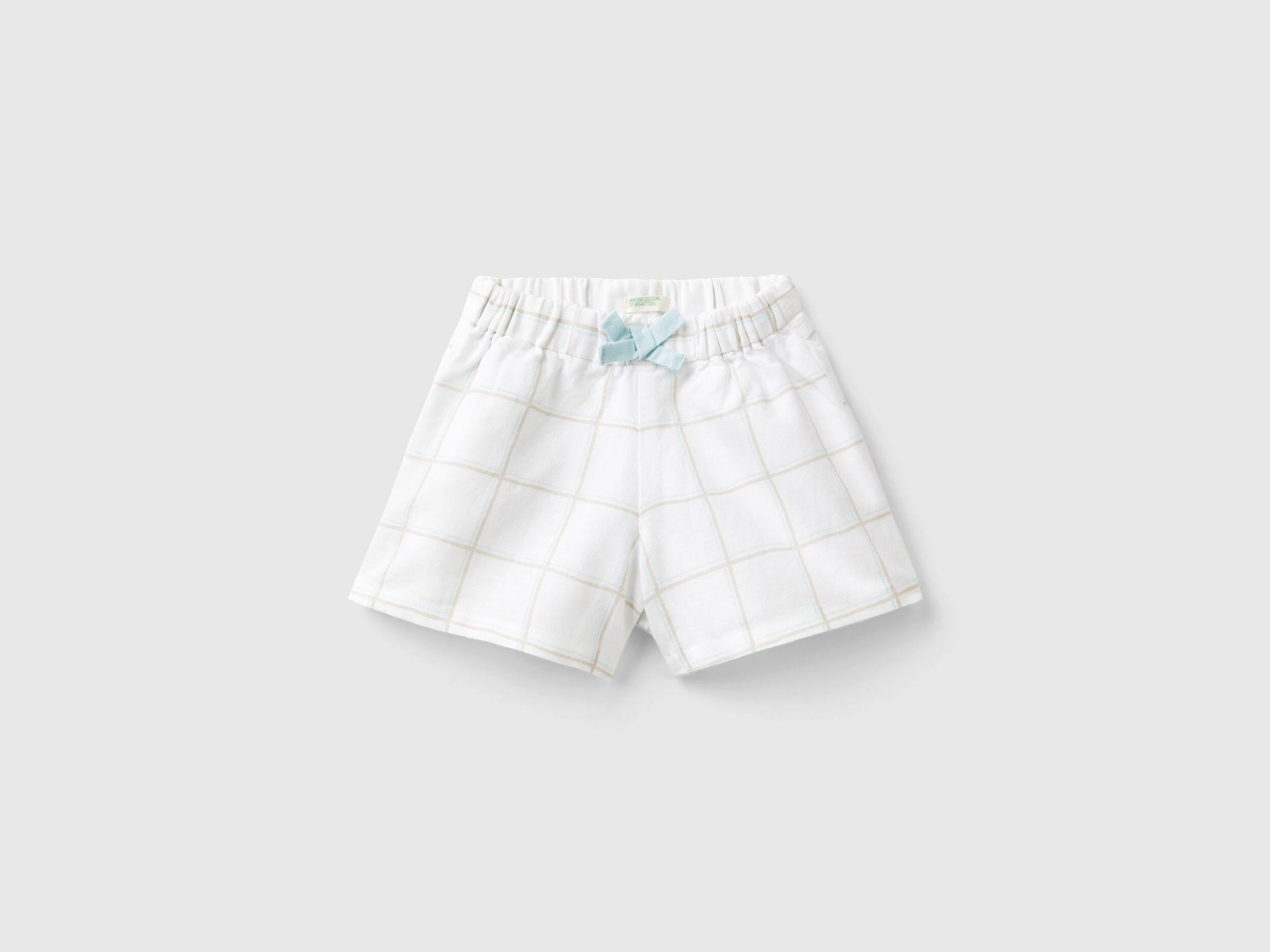 Front view of white and blue checkered culottes for kids, featuring a cute bow detail at the waist.