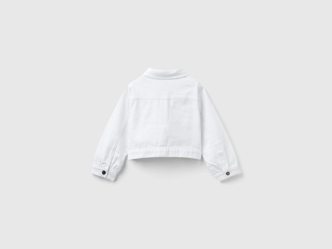 Back view of a white cropped jacket, showcasing its clean lines and fitted design.