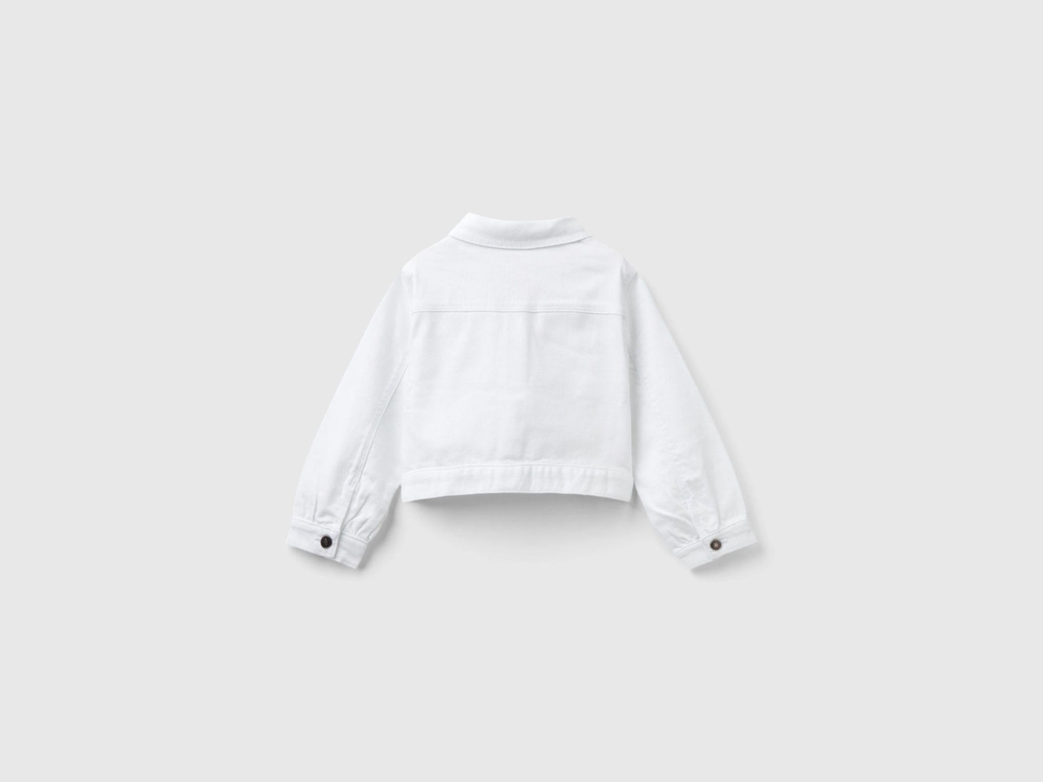 Back view of a white cropped jacket, showcasing its clean lines and fitted design.