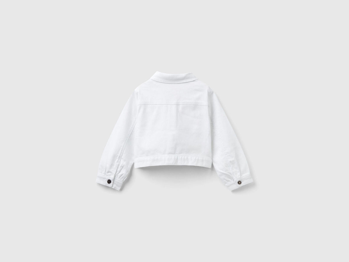 Back view of a white cropped jacket, showcasing its clean lines and fitted design.