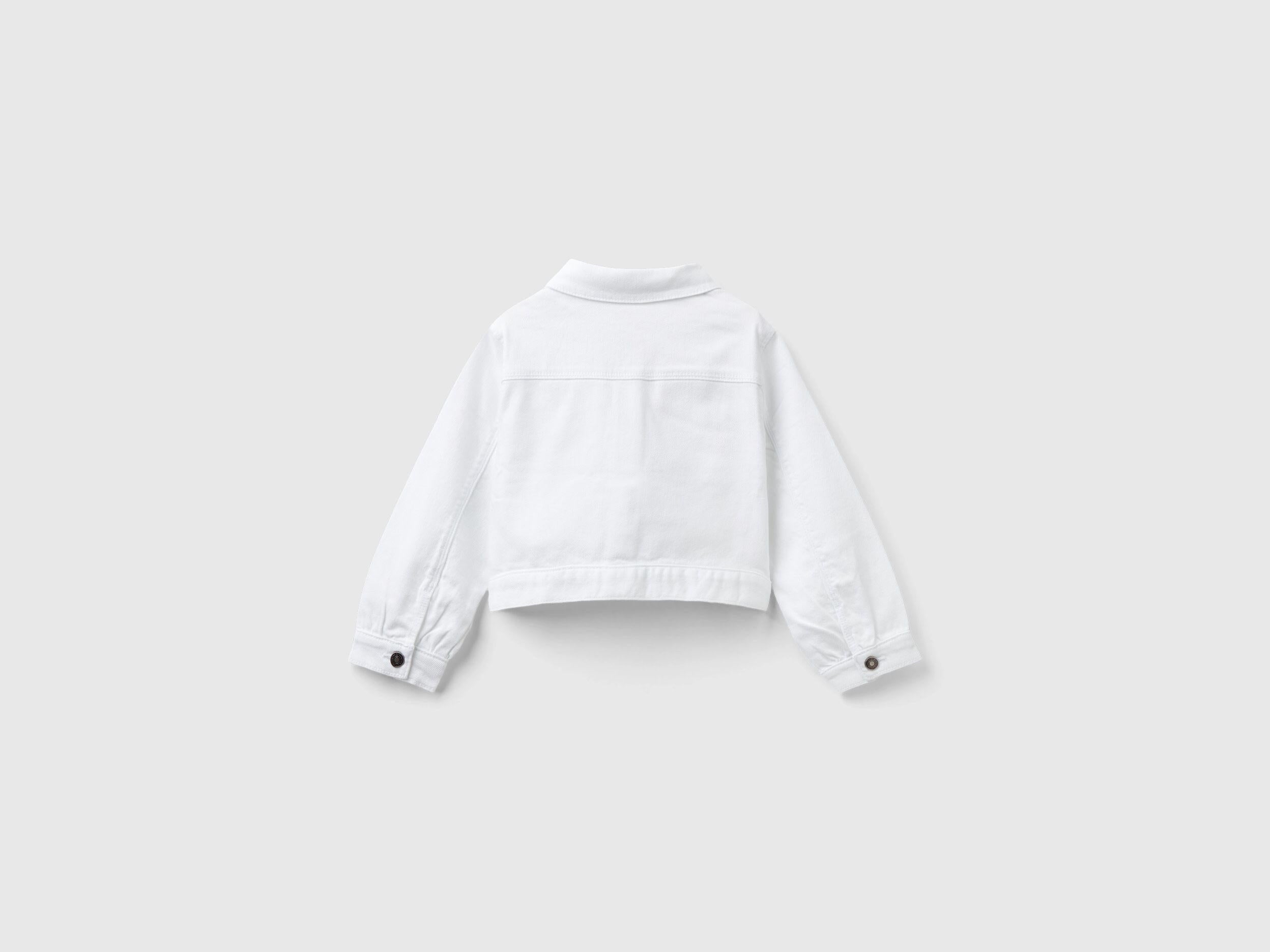 Back view of a white cropped jacket, showcasing its clean lines and fitted design.