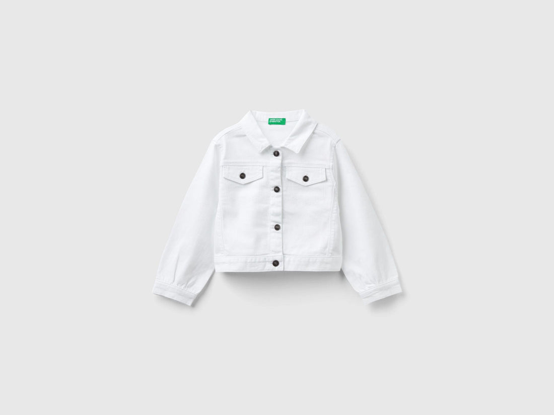 Front view of a white cropped jacket in stretch cotton denim, featuring silver buttons and a classic collar.