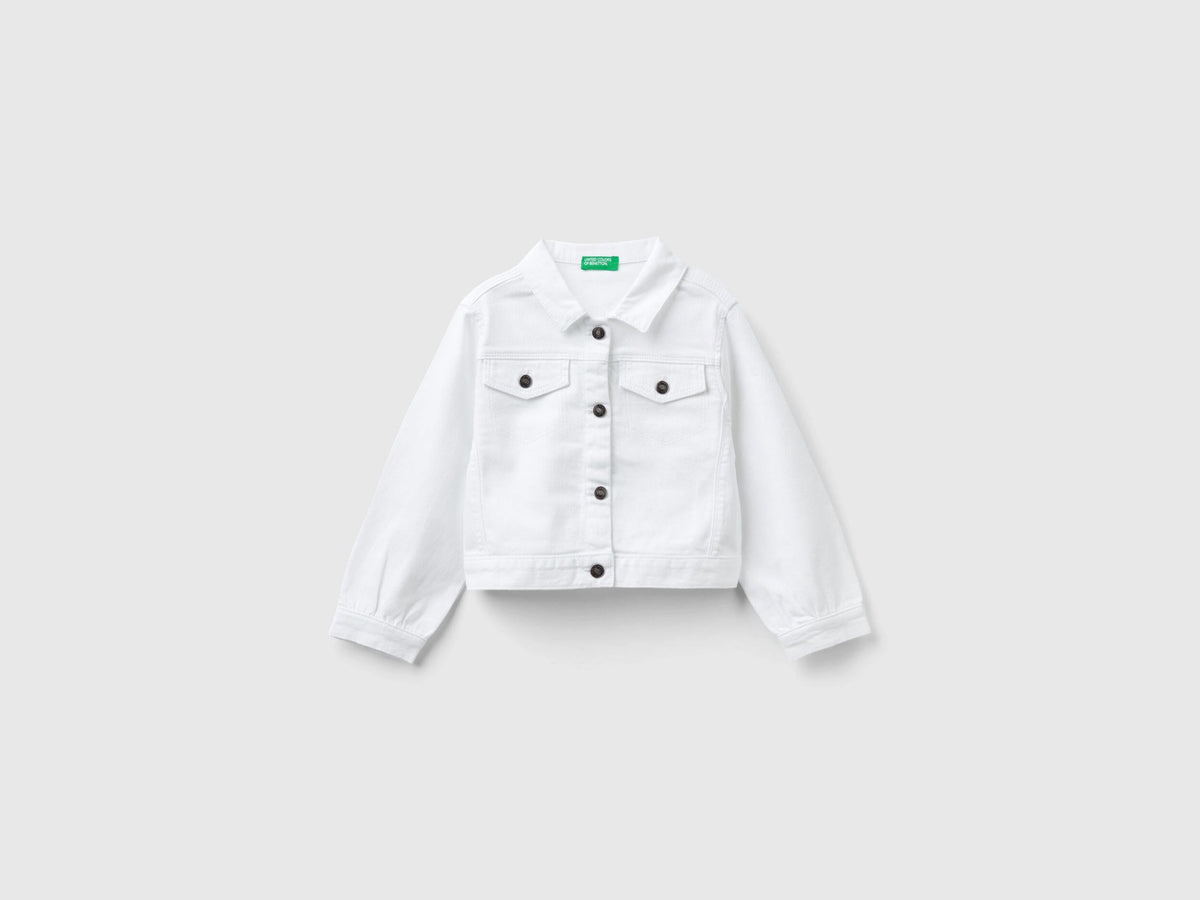 Front view of a white cropped jacket in stretch cotton denim, featuring silver buttons and a classic collar.