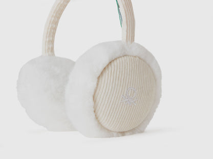 Close-up of white faux fur earmuffs, corduroy texture.