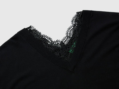Close-up of a black lace top for women, showing the intricate V-neck lace trim.
