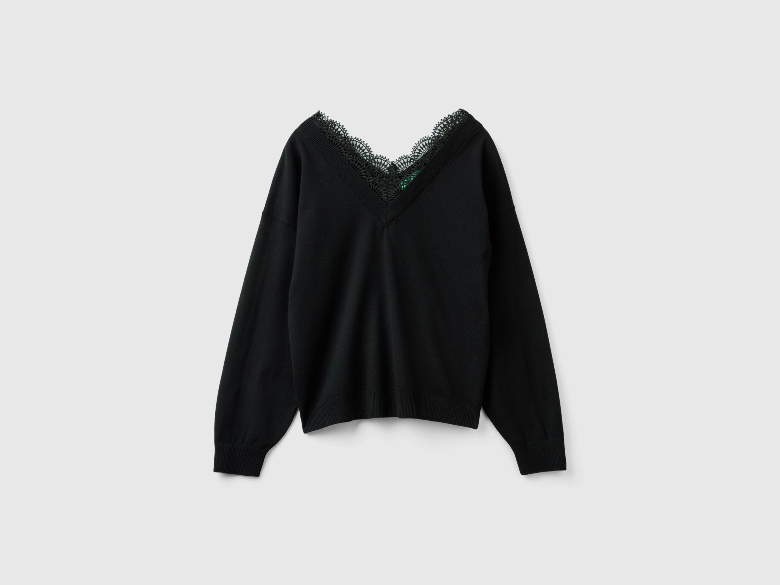 Flat lay front view of a black flowy top for women with lace V-neck.