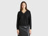 Front view of a woman wearing a black flowy top with lace trim.