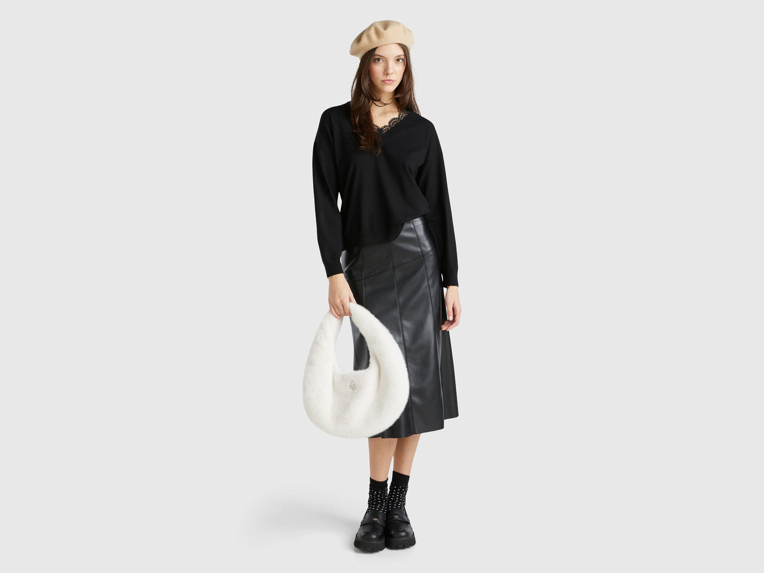Full outfit of a woman wearing a black lace top, leather skirt, and beret.