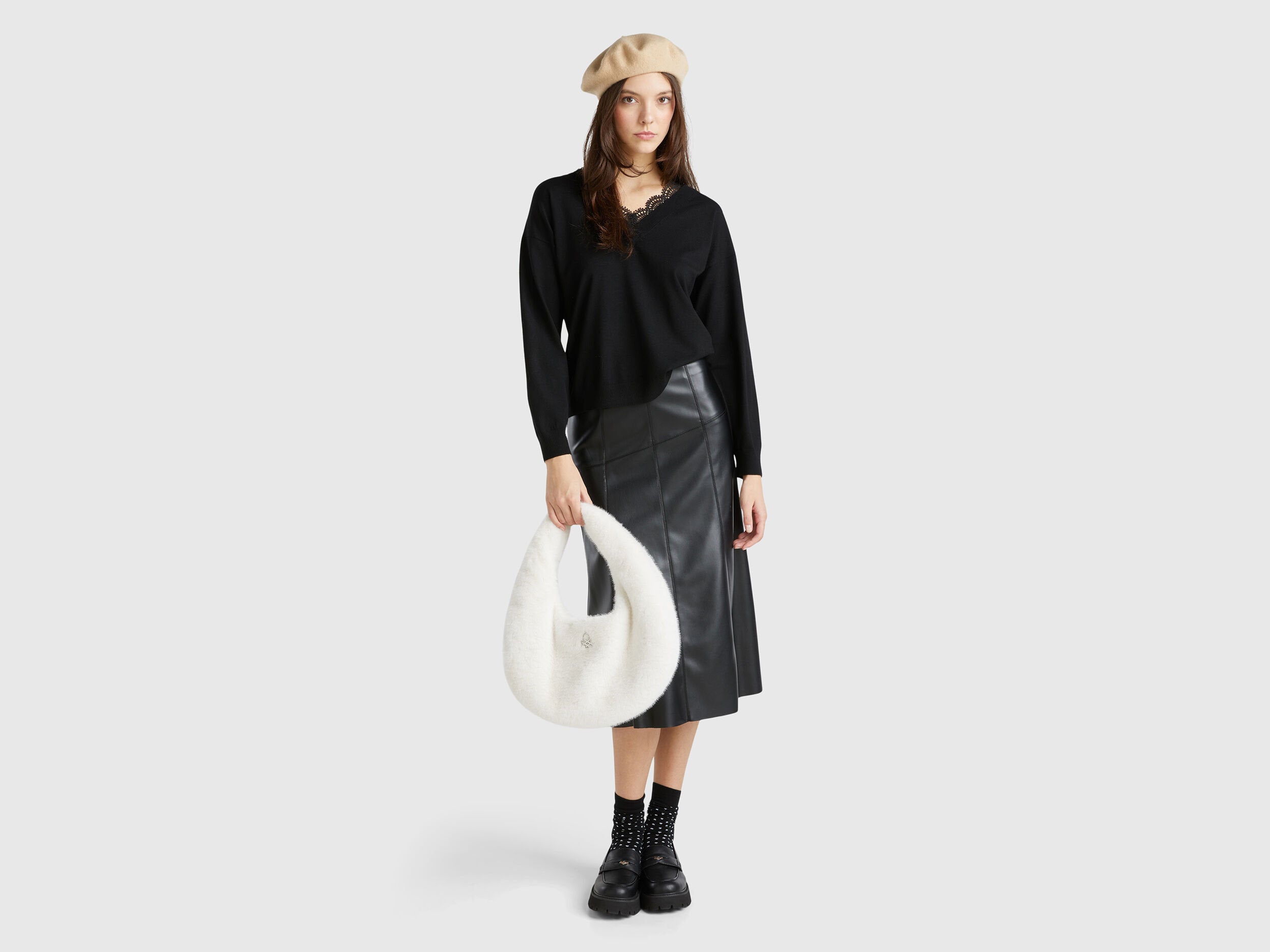 Full outfit of a woman wearing a black lace top, leather skirt, and beret.