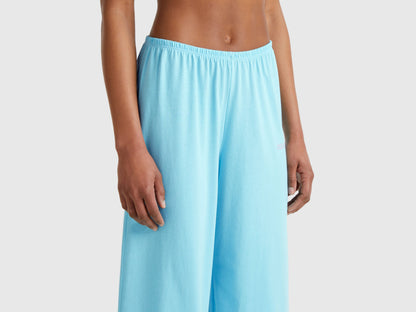 Close-up of the bottom half of a light blue loose-fitting pyjama set for women.