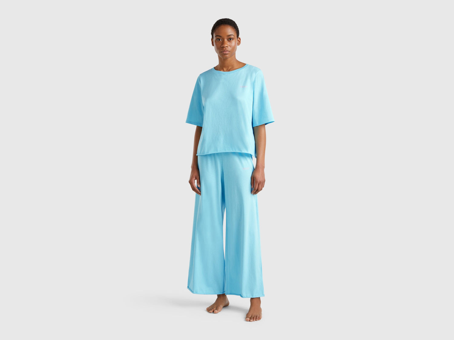 Front view of a woman wearing a light blue loose-fitting pyjama set.