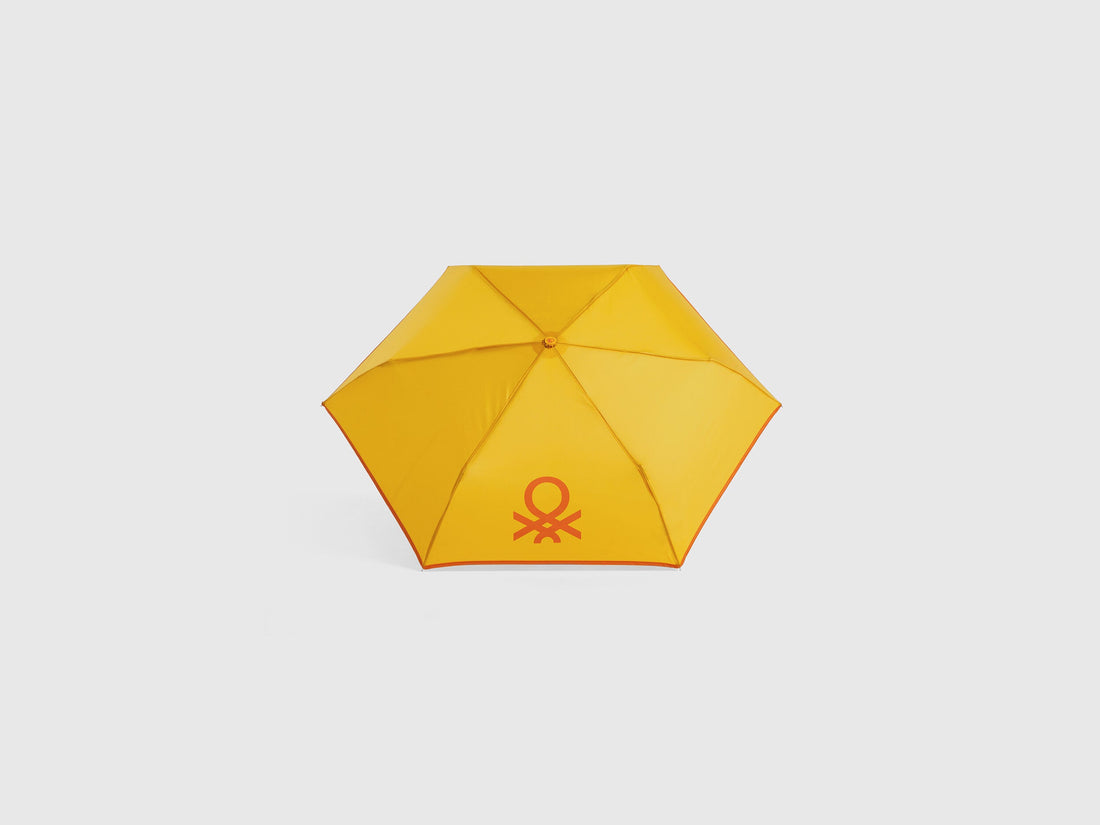 Open yellow Benetton umbrella, top view for rain protection.
