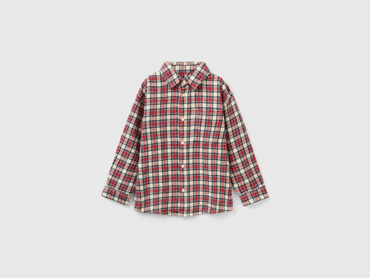 A Boys model wearing long-sleeve checked shirt over a white T-shirt, a classic casual look for Kuwait.