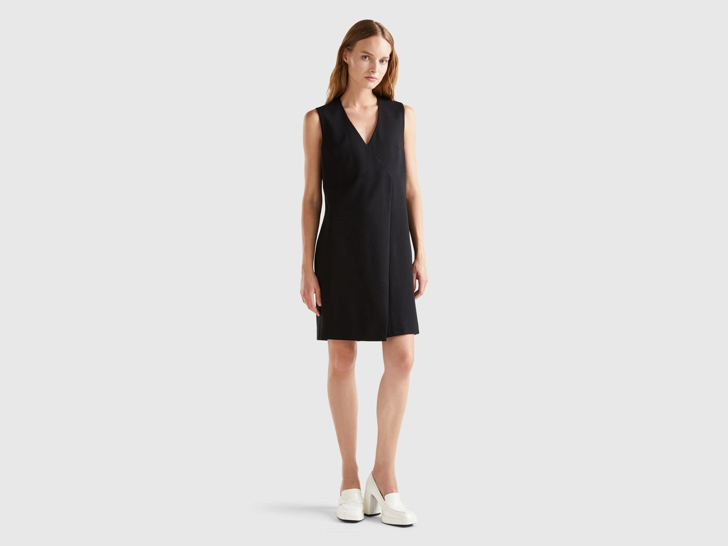 Front view of a female model wearing an elegant wrap dress.