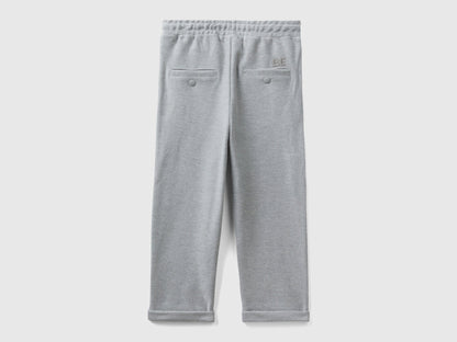 Back view of folded grey carrot fit joggers with subtle embroidery.