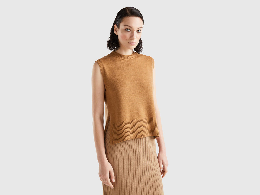 Front view of a woman wearing a light brown knit vest and matching skirt.