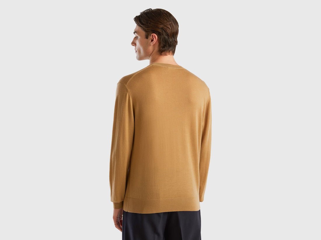 Back view of a man wearing a plain beige sweater.