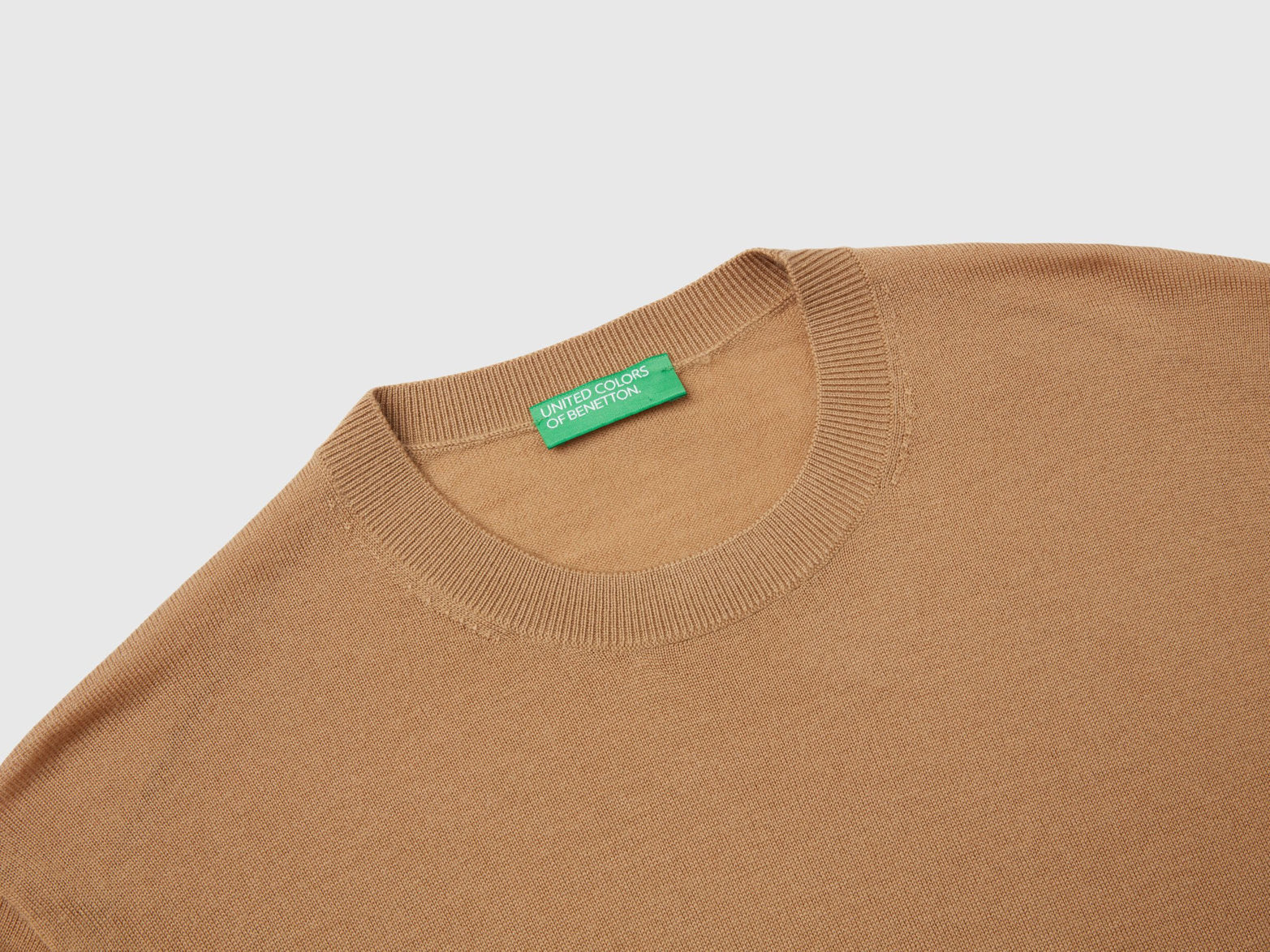 Close-up of the ribbed cuff and texture of a beige sweater for men.