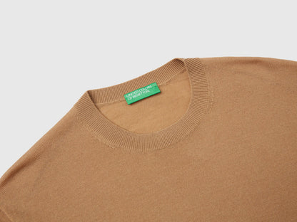 Close-up of the ribbed cuff and texture of a beige sweater for men.