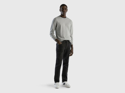 Full-length front view of a man wearing black slim-fit jeans.
