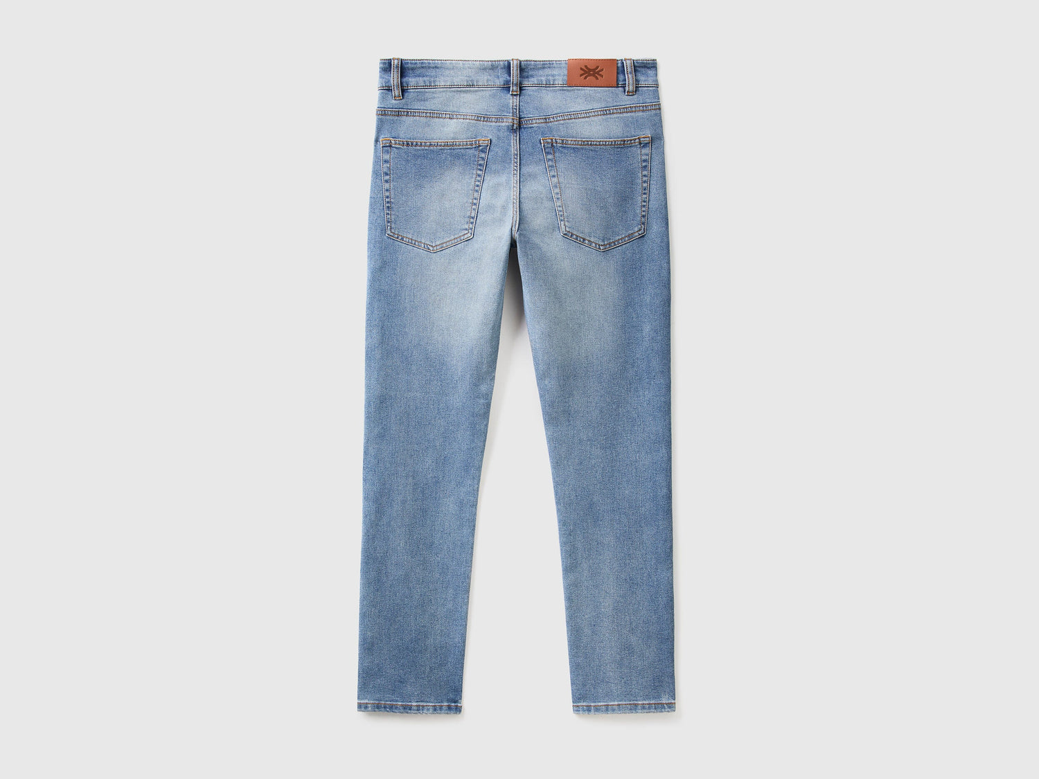 Close-up of the back pocket and stitching on black slim-fit jeans.