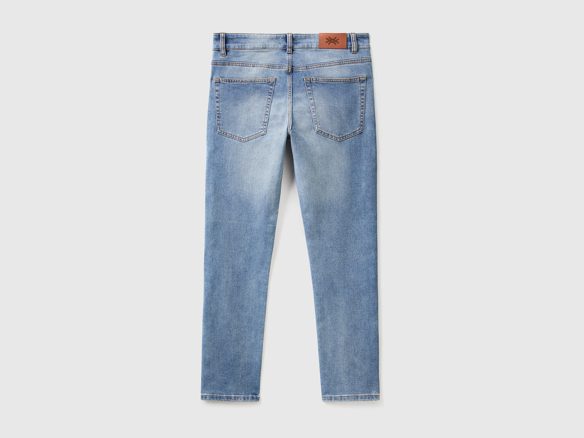 Close-up of the back pocket and stitching on black slim-fit jeans.