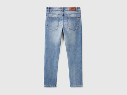 Close-up of the back pocket and stitching on black slim-fit jeans.