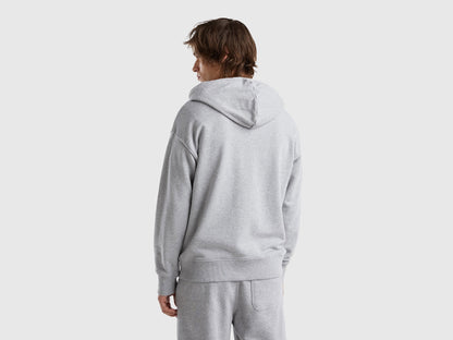 Back view of a man wearing a plain grey cotton zip-up hoodie.