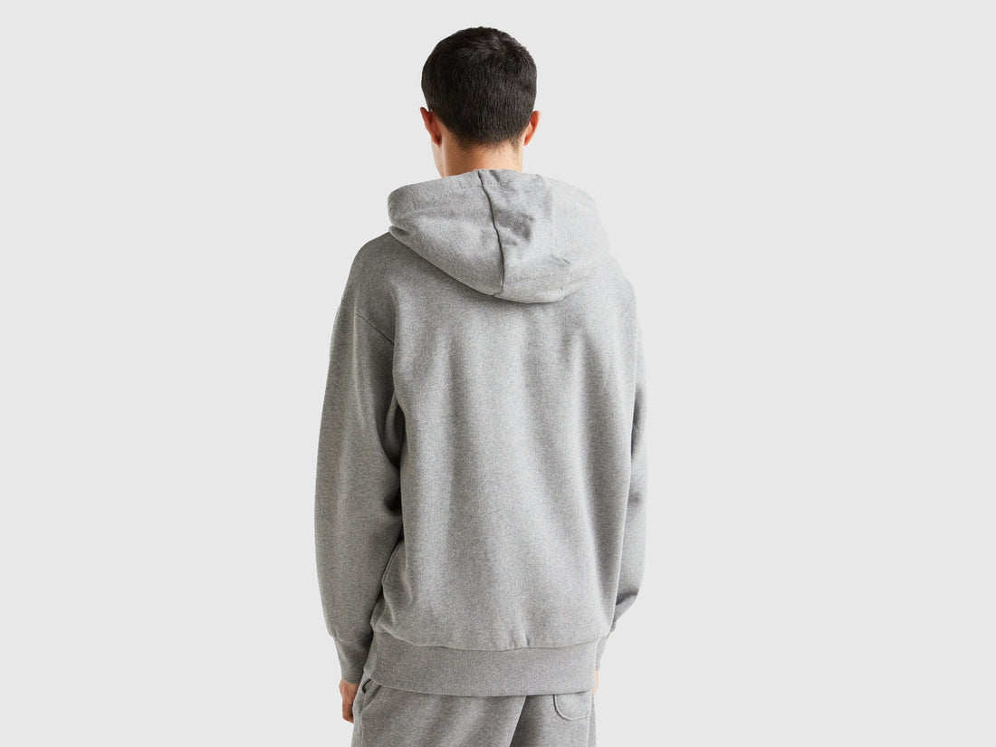 Back view of a man wearing a plain grey hoodie.