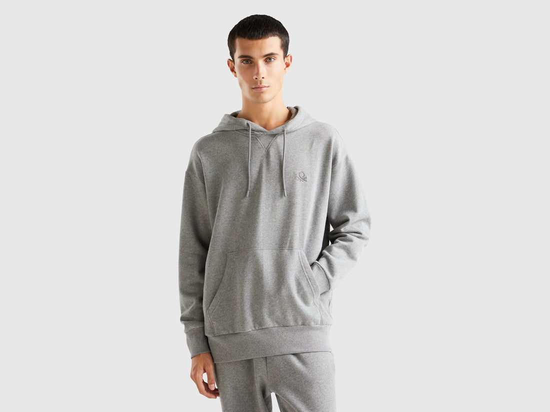 Front view of a man wearing a plain grey hoodie.