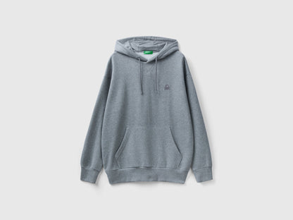 Side view of a man wearing a plain grey hoodie.