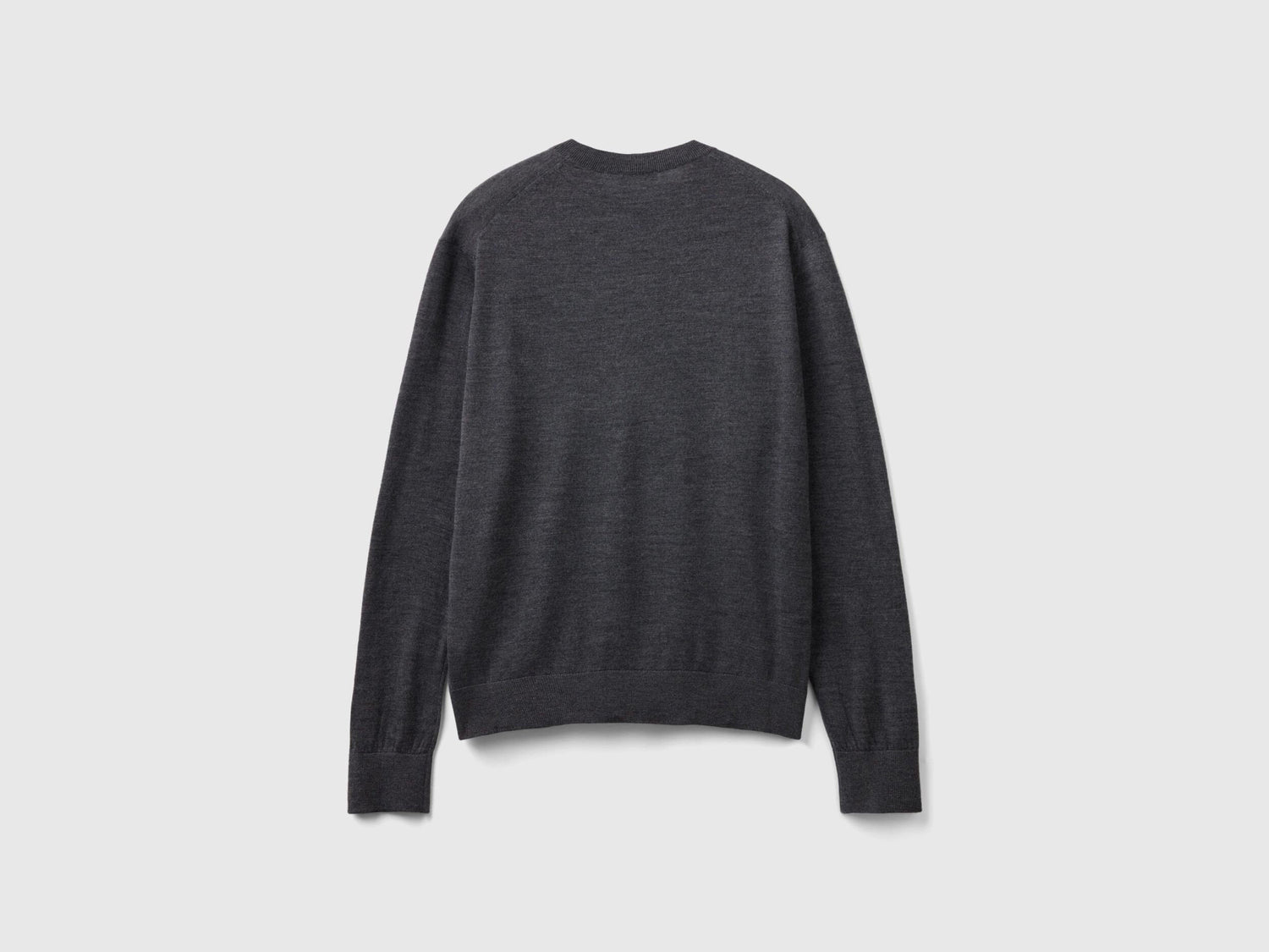 Side view of a man wearing a grey merino wool sweater.