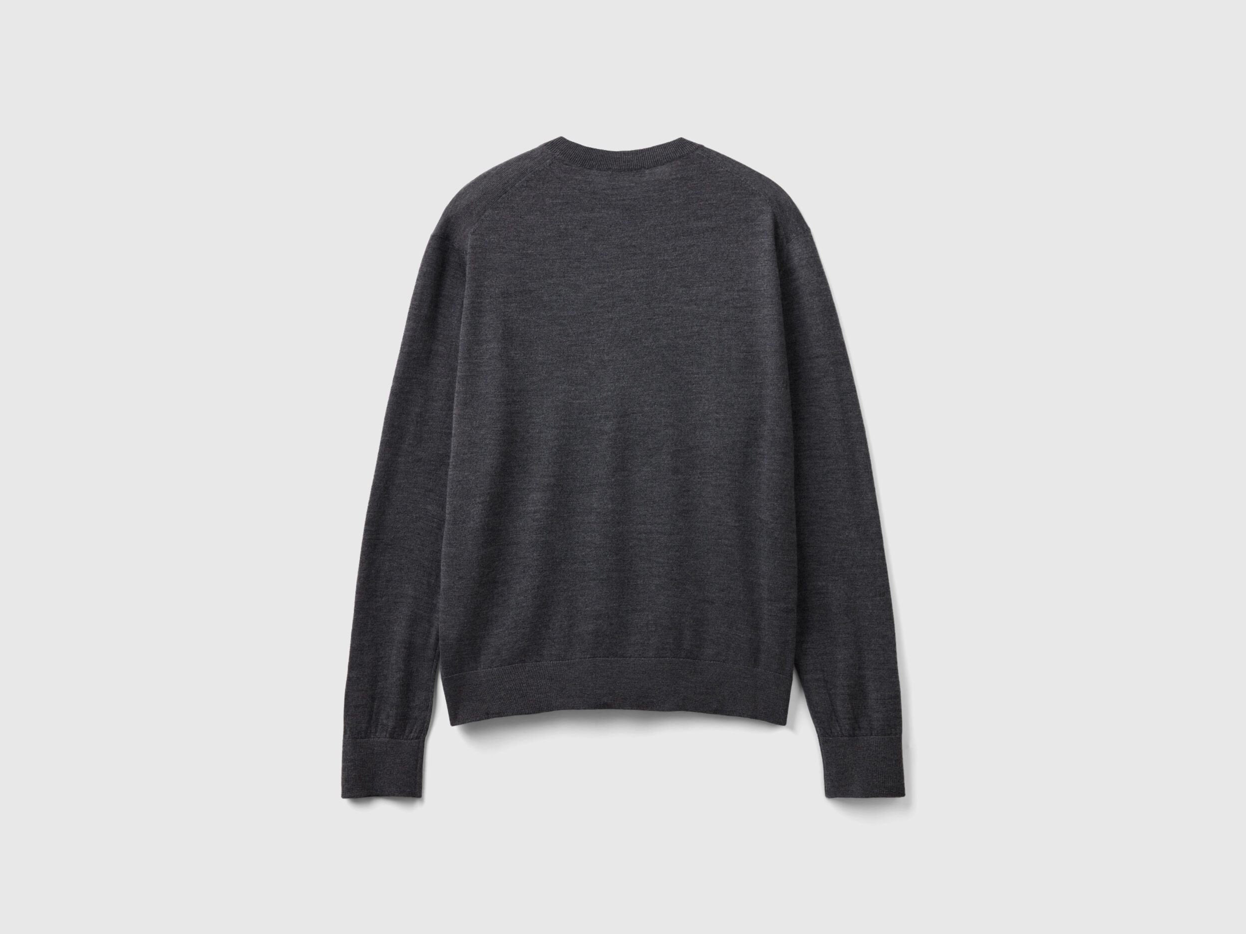 Side view of a man wearing a grey merino wool sweater.