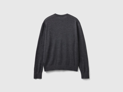 Side view of a man wearing a grey merino wool sweater.