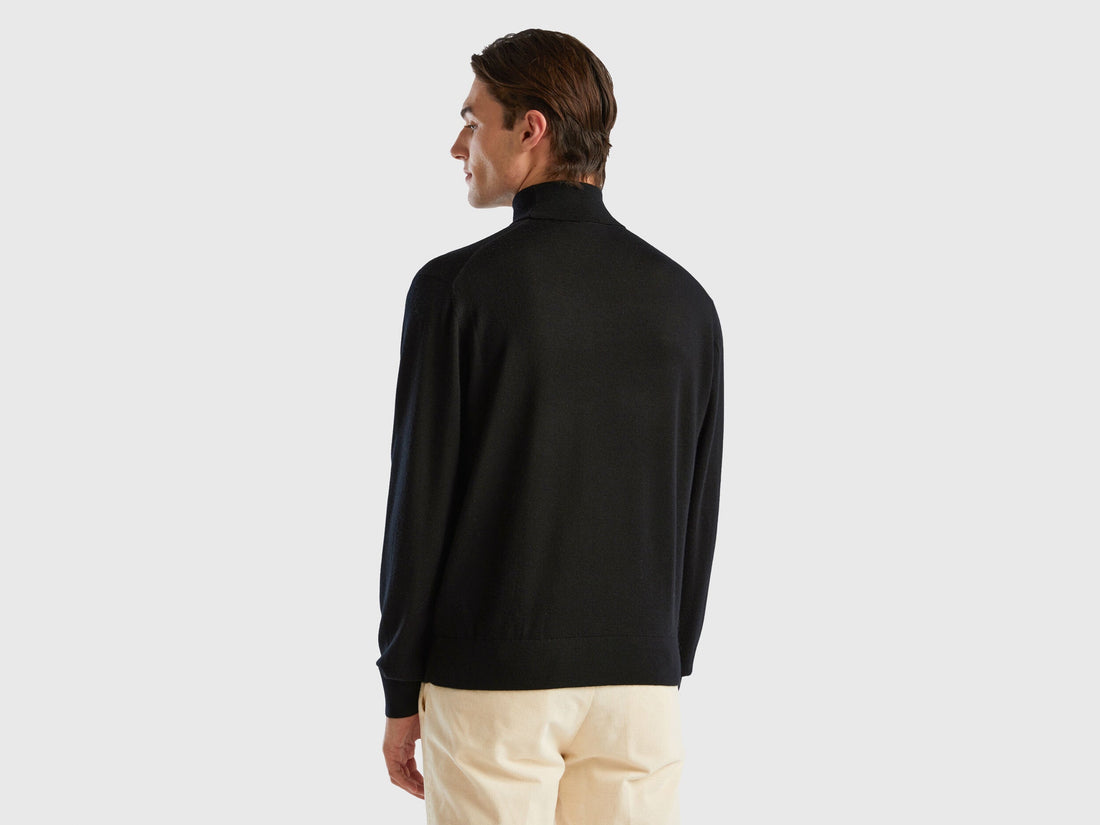 Back view of a man wearing a black turtleneck sweater.