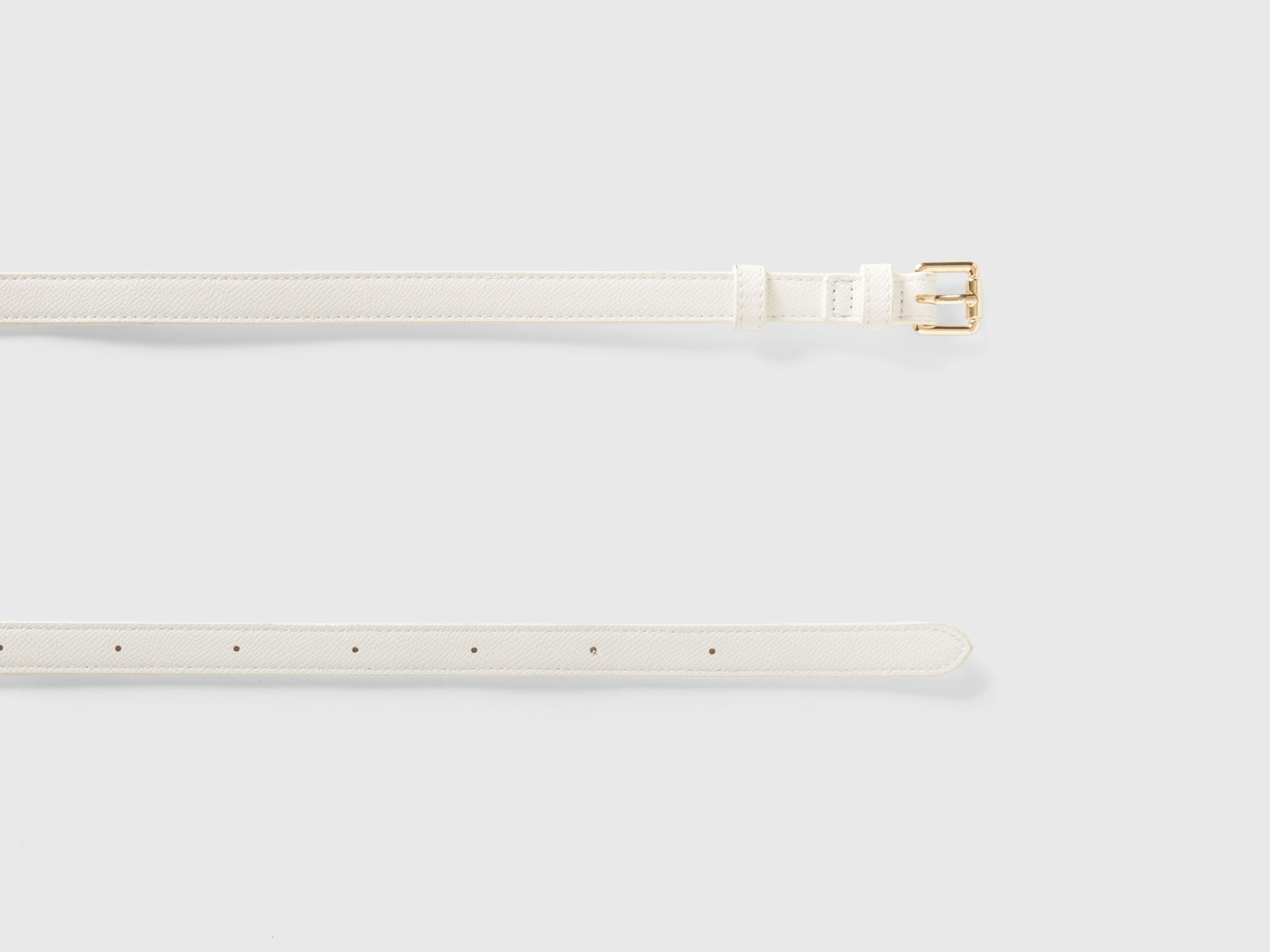 Unrolled white crocodile print corset belt, showcasing texture and gold buckle detail.