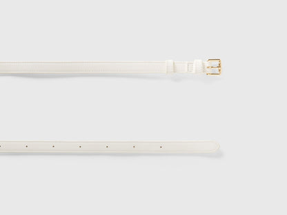 Unrolled white crocodile print corset belt, showcasing texture and gold buckle detail.